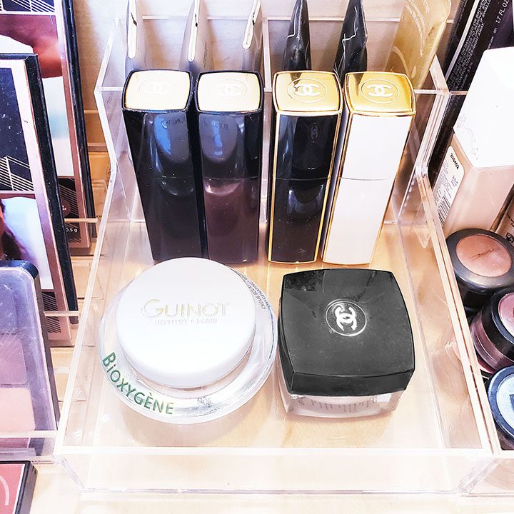 Chanel makeup products neatly organized in a clear case to help you declutter and streamline your beauty routine.