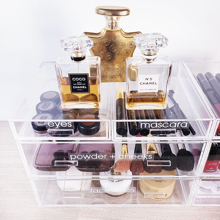 Organize your makeup with a clear makeup organizer filled with cosmetics and perfumes.