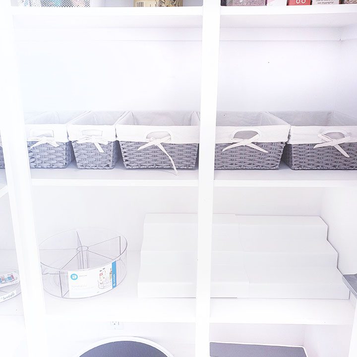 A white closet with a lot of baskets on it.