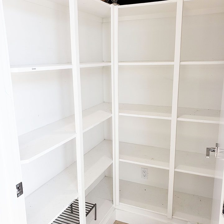A white closet with shelves that are open.