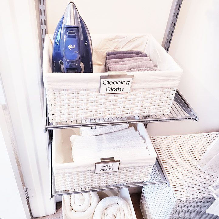 Create an organized laundry room with baskets, towels, and an ironing board to effectively organize your linen closet.