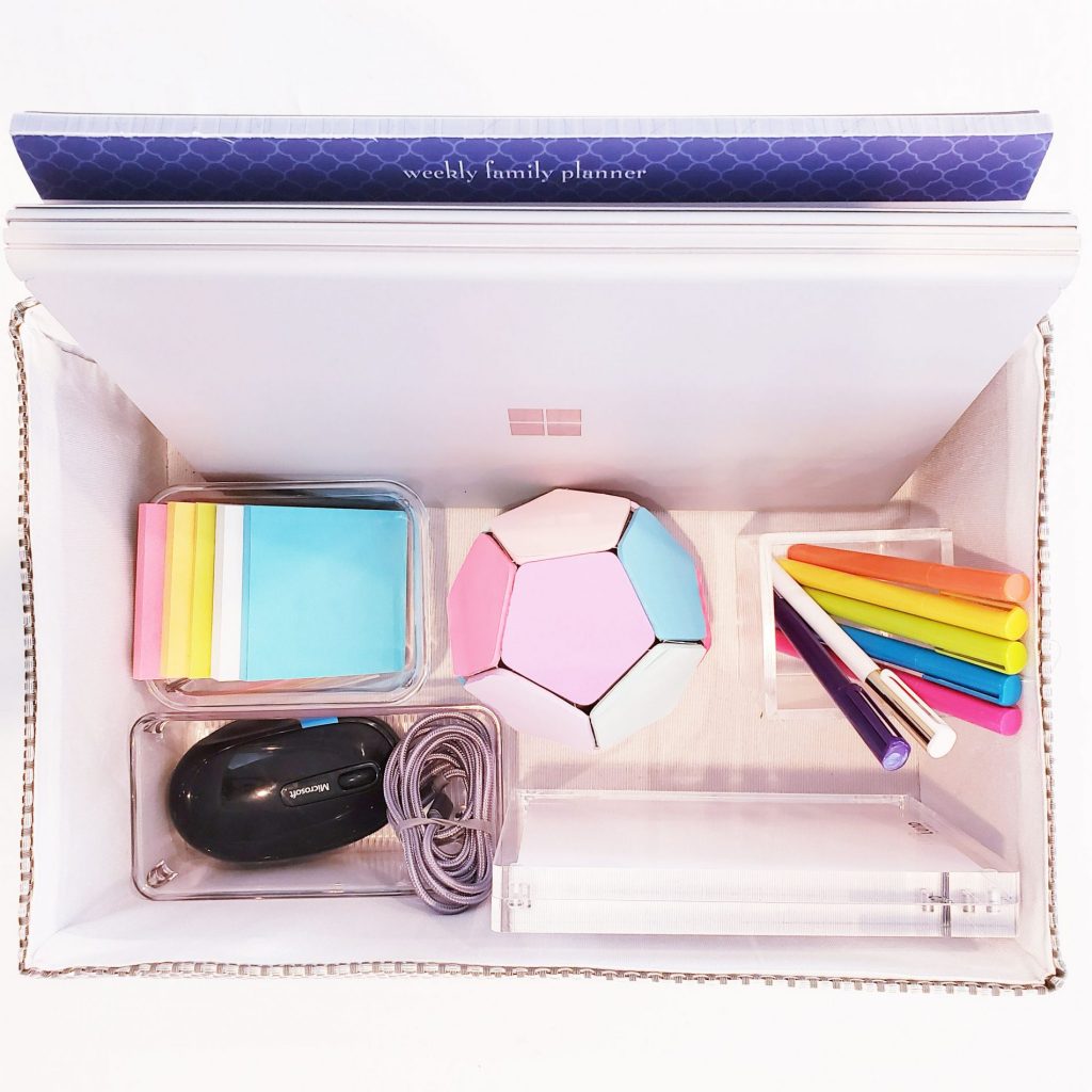 Organize your desktop with a white box filled with pens, pencils, and other office supplies.