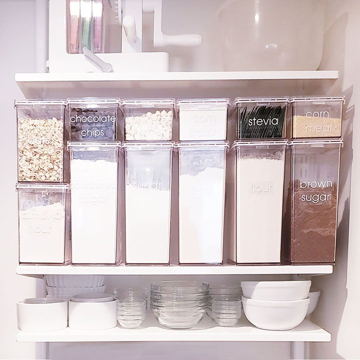 A kitchen pantry with a variety of containers and bowls.
