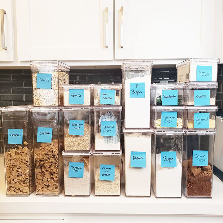 A pantry filled with a variety of containers with labels on them.
