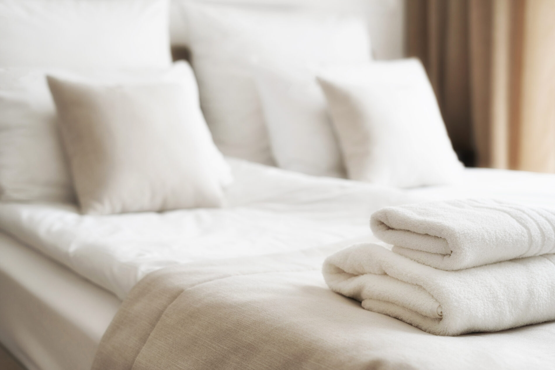 Neatly folded towels on a bed in a hotel room showcasing the meticulous habits of the staff.