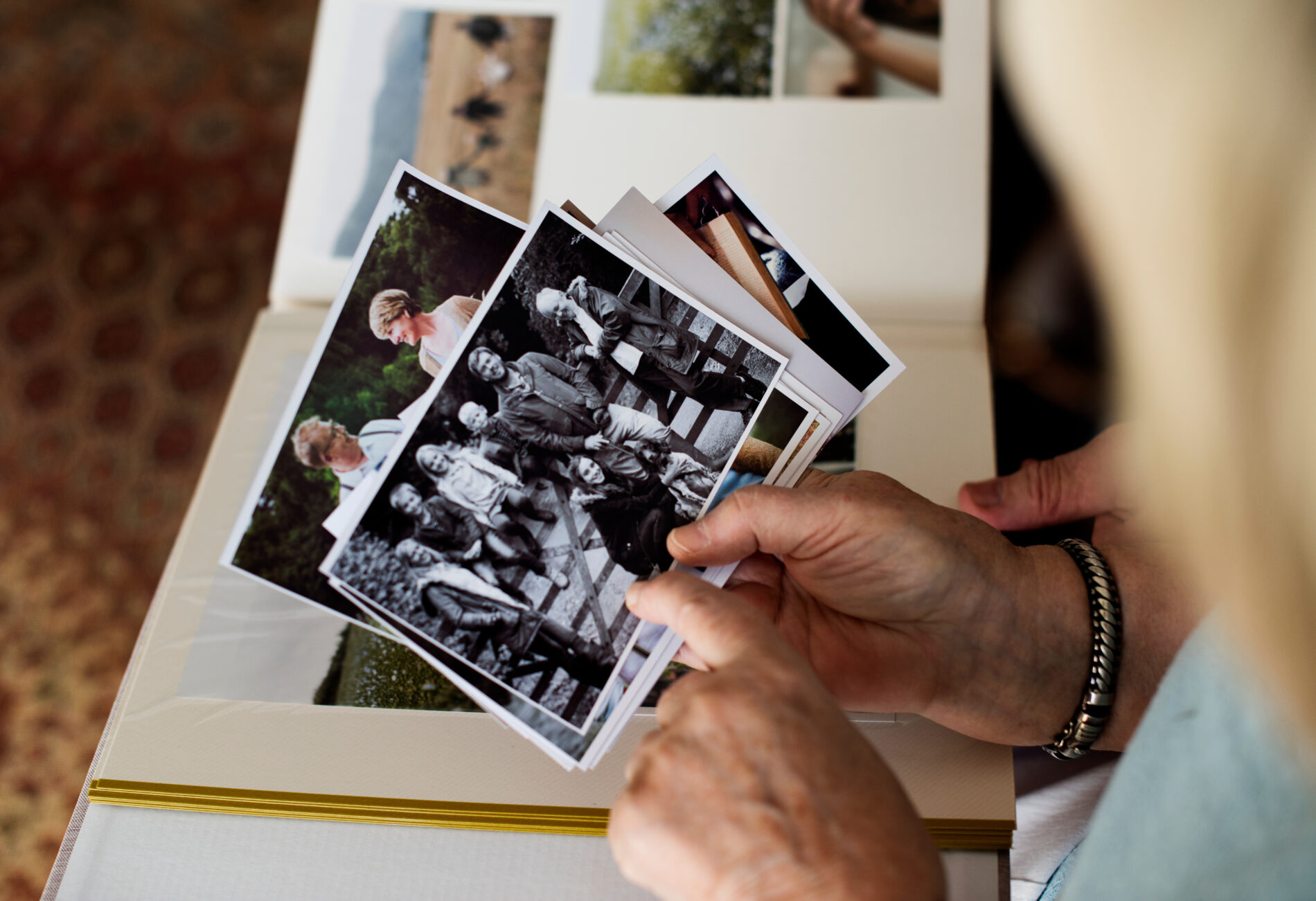 A woman cherishing old memories while flipping through a photo album.