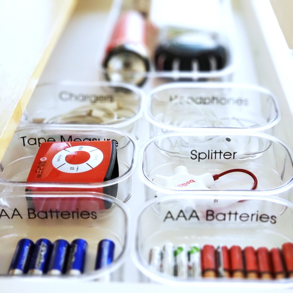 A drawer filled with a variety of items that is in need of some spring cleaning.