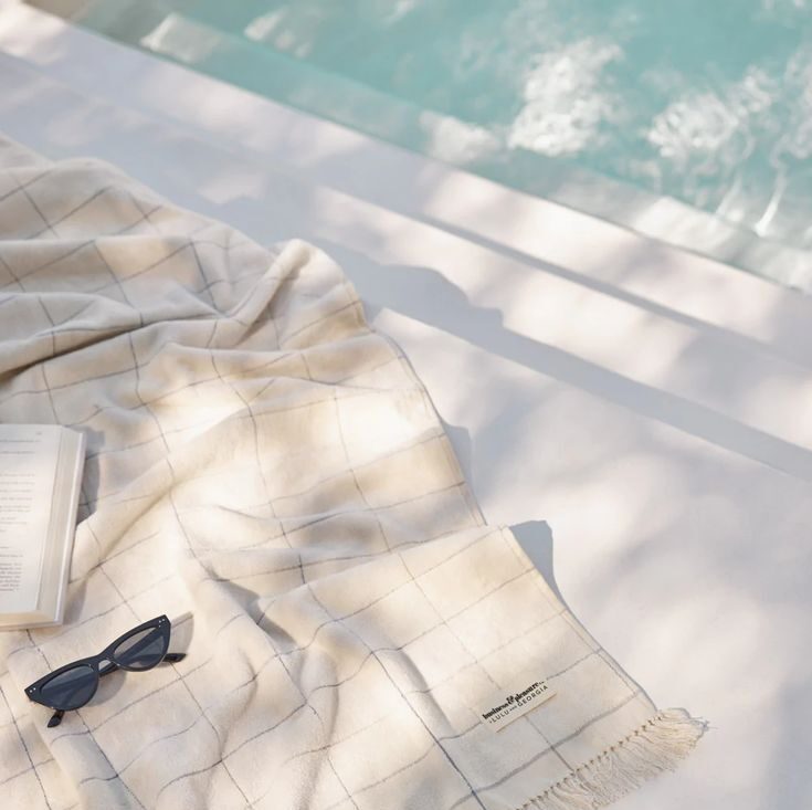 A summer towel on a table next to a pool.