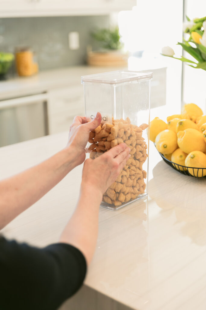 A woman with celiac disease is carefully placing peanuts into a clear container.