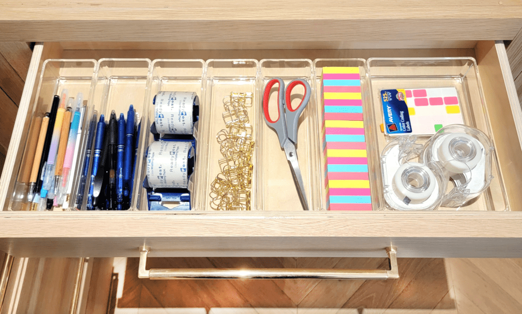 A drawer filled with a variety of office supplies.