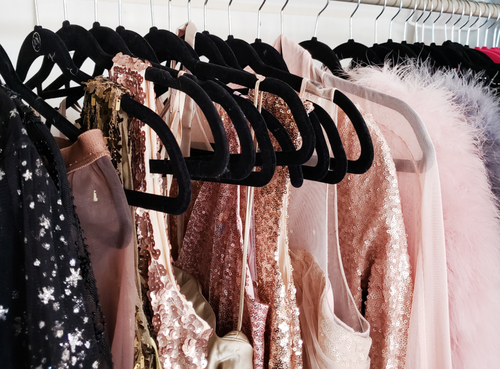 Assorted dresses hanging on black velvet hangers.
