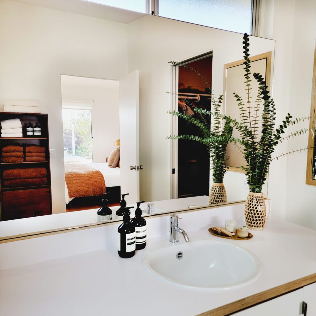 Modern bathroom with plants and towels.