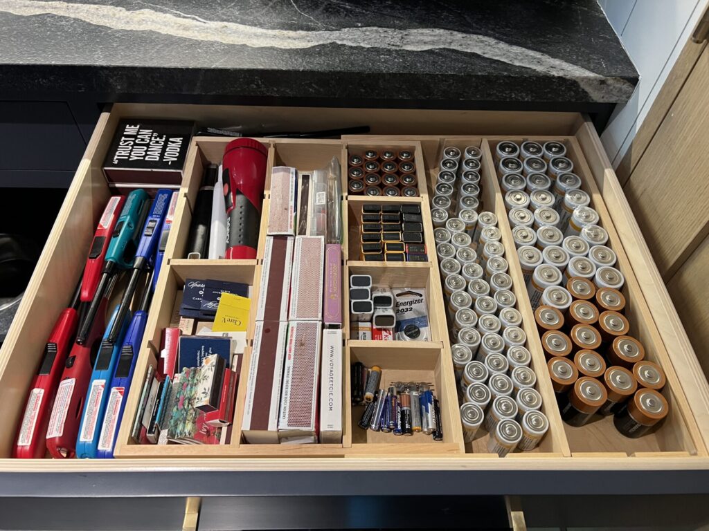 Organized drawer with batteries and supplies.