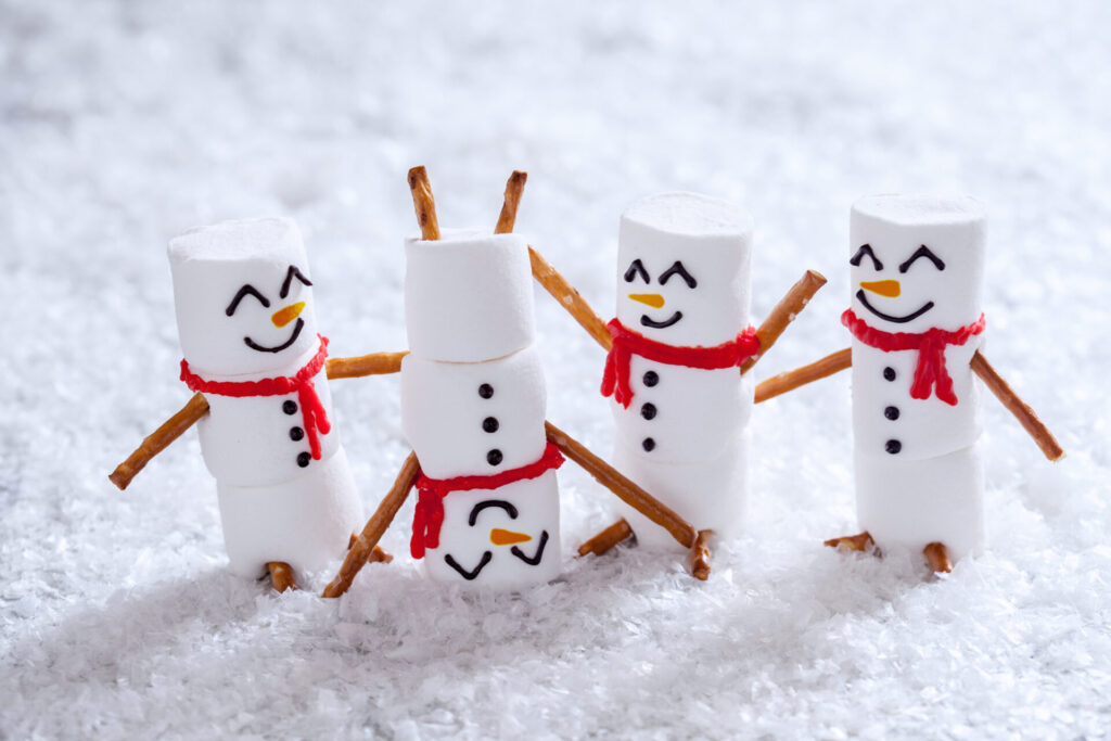 Marshmallow snowmen with pretzel arms and scarves.