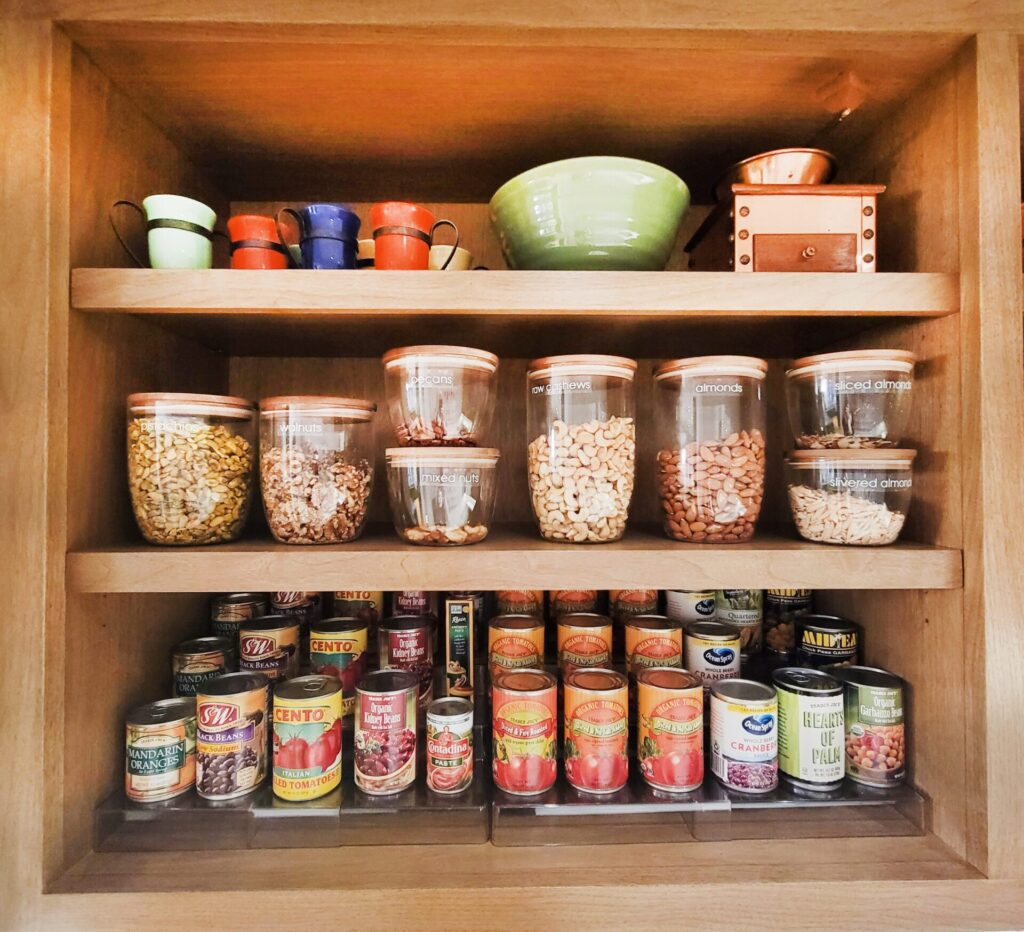 Organized pantry shelves with nuts and canned goods.